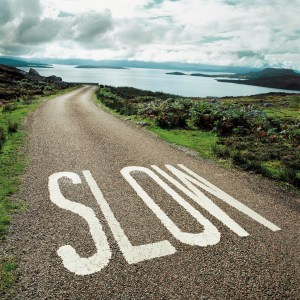 Road leading to the ocean with 'slow' painted on it